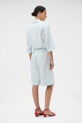 Profile view of model wearing the Oroton Tab Detail Culotte in Ice Blue and 100% heavy weight linen fabric for Women .