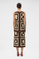 Profile view of model wearing the Oroton Graphic Shell Slip Skirt in Dark Chocolate and 100% silk twill fabric for Women .
