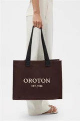 Profile view of model wearing the Oroton Everyday Tote in Chocolate and Crafted from 99.9% recycled polyester material for Women .