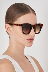 Profile view of model wearing the Oroton Duo Sunglasses in Signature Tort and Premium acetate material for Women .