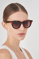 Profile view of model wearing the Oroton Heidi Sunglasses in Signature Tort and Premium acetate material for Women