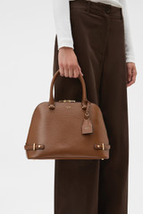 Profile view of model wearing the Oroton Grace Grip Top in Cinnamon and Premium Saffiano leather body for Women .