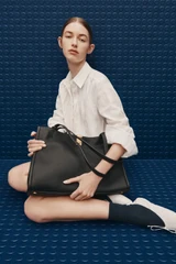 Profile view of model wearing the Oroton Mille Work Tote in Black and Premium pebble leather for Women .