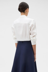 Profile view of model wearing the Oroton Stitch Detail Shirt in White and 100% linen fabric for Women .