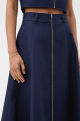 Profile view of model wearing the Oroton Zip Midi Skirt in North Sea and 100% cotton fabric for Women .