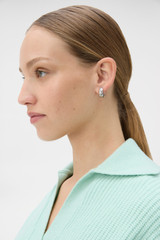 Profile view of model wearing the Oroton Arden Crystal Large Huggies in Silver/Crystal and Brass material for Women .