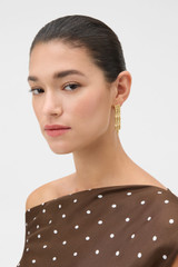 Profile view of model wearing the Oroton Chloe Earrings in Worn Gold and 14k yellow gold-plated brass with Oroton’s signature soft-burnished finish for Women .