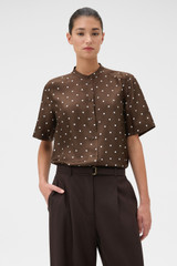 Profile view of model wearing the Oroton Graphic Spot Top in Dark Chocolate and 100% Silk for Women .