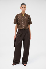 Profile view of model wearing the Oroton Graphic Spot Top in Dark Chocolate and 100% Silk for Women .