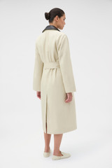 Profile view of model wearing the Oroton Essential Mac in Limestone and 77% cotton and 23% linen blend fabric body with a 100% leather collar for Women .