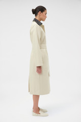 Profile view of model wearing the Oroton Essential Mac in Limestone and 77% cotton and 23% linen blend fabric body with a 100% leather collar for Women .