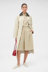 Profile view of model wearing the Oroton Essential Mac in Limestone and 77% cotton and 23% linen blend fabric body with a 100% leather collar for Women .