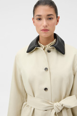 Profile view of model wearing the Oroton Essential Mac in Limestone and 77% cotton and 23% linen blend fabric body with a 100% leather collar for Women .