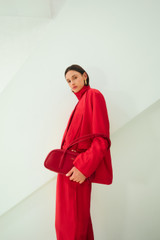 Profile view of model wearing the Oroton Soft Double Breasted Blazer in Ribbon Red and 77% viscose and 23% polyamide blend fabric for Women .