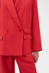 Profile view of model wearing the Oroton Soft Double Breasted Blazer in Ribbon Red and 77% viscose and 23% polyamide blend fabric for Women .