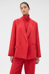 Profile view of model wearing the Oroton Soft Double Breasted Blazer in Ribbon Red and 77% viscose and 23% polyamide blend fabric for Women .