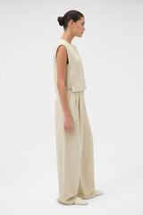 Profile view of model wearing the Oroton Pleat Detail Pant in Almond Creme and 72% viscose and 28% linen blend fabric for Women .