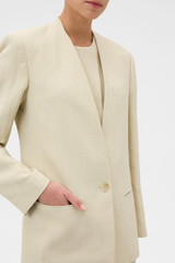 Profile view of model wearing the Oroton Single Breasted Blazer in Almond Creme and 72% Viscose, 28% linen for Women .