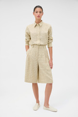 Profile view of model wearing the Oroton Pleat Check Short in Pale Lemon/Chocolate and 87% viscose and 13% polyester blend fabric for Women .