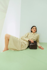 Profile view of model wearing the Oroton Pleat Check Short in Pale Lemon/Chocolate and 87% viscose and 13% polyester blend fabric for Women .