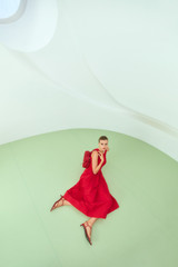 Profile view of model wearing the Oroton Knit Bodice Midi Dress in Ribbon Red and Knit: 100% cotton; Skirt: 77% viscose, 23% polyester for Women .