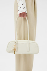 Profile view of model wearing the Oroton Louisa Shoulder Bag in Clotted Cream and Premium smooth leather for Women .