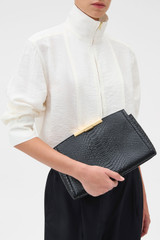 Profile view of model wearing the Oroton Miriam Textured Day Bag in Black Snake and Premium embossed leather for Women .