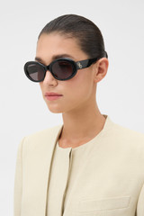 Profile view of model wearing the Oroton Soren Sunglasses in Black and Made from Acetate material for Women .