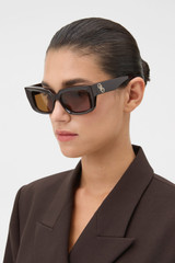 Profile view of model wearing the Oroton Spencer Sunglasses in Chocolate and Made from Acetate material for Women .