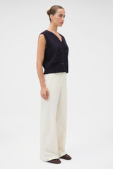 Profile view of model wearing the Oroton Folk Straight Leg Pant in Whipped Cream and 96% cotton and 4% elastane fabric for Women .