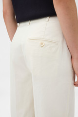 Profile view of model wearing the Oroton Folk Straight Leg Pant in Whipped Cream and 96% cotton and 4% elastane fabric for Women .