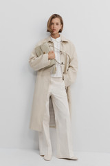 Profile view of model wearing the Oroton Folk Straight Leg Pant in Whipped Cream and 96% cotton and 4% elastane fabric for Women .