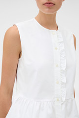 Profile view of model wearing the Oroton Oxford Peplum Top in Antique White and 100% cotton oxford fabric for Women .