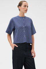 Profile view of model wearing the Oroton Check Tie Neck Shirt in North Sea and 100% cotton fabric for Women .