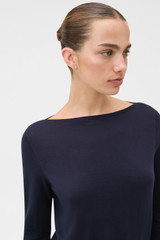 Profile view of model wearing the Oroton Fine Slash Neck Knit in North Sea and 100% Pima cotton yarn fabric for Women .