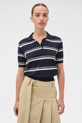 Profile view of model wearing the Oroton Short Sleeve Stripe Knit Polo in North Sea and 100% Pima cotton yarn fabric for Women .
