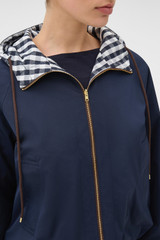 Profile view of model wearing the Oroton Reversible Check Windbreaker in North Sea and 100% polyester fabric for Women .