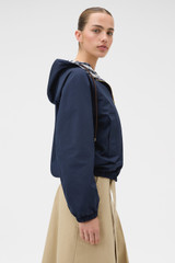 Profile view of model wearing the Oroton Reversible Check Windbreaker in North Sea and 100% polyester fabric for Women .