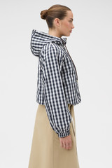 Profile view of model wearing the Oroton Reversible Check Windbreaker in North Sea and 100% polyester fabric for Women .