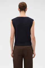 Profile view of model wearing the Oroton Milano Knit Vest in North Sea and 93% mercerised cotton yarn, 6% nylon, and 1% elastane blend fabric for Women .