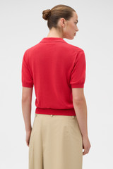 Profile view of model wearing the Oroton Short Sleeve Knit Polo in Market Red and 100% Pima Cotton Yarn for Women .