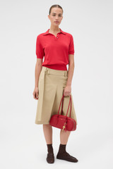 Profile view of model wearing the Oroton Short Sleeve Knit Polo in Market Red and 100% Pima Cotton Yarn for Women .