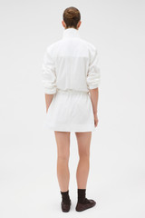 Profile view of model wearing the Oroton Zip Detail Anorak Dress in Antique White and 100% cotton fabric for Women .