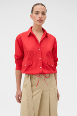 Profile view of model wearing the Oroton Poplin Drawstring Shirt in Market Red and 100% cotton fabric for Women .