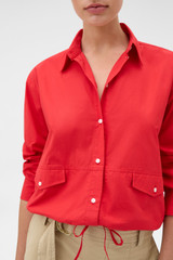 Profile view of model wearing the Oroton Poplin Drawstring Shirt in Market Red and 100% cotton fabric for Women .