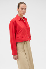 Profile view of model wearing the Oroton Poplin Drawstring Shirt in Market Red and 100% cotton fabric for Women .