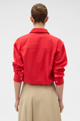 Profile view of model wearing the Oroton Poplin Drawstring Shirt in Market Red and 100% cotton fabric for Women .