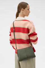 Profile view of model wearing the Oroton Dorit Small Day Bag in Olive and Premium pebble leather for Women .