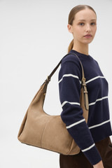 Profile view of model wearing the Oroton Dorit Nubuck Hobo in Stone and Premium nubuck leather for Women .