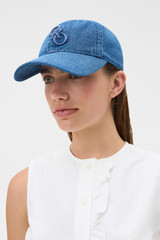 Profile view of model wearing the Oroton Denim Cap in Denim and 100% cotton for Women .
